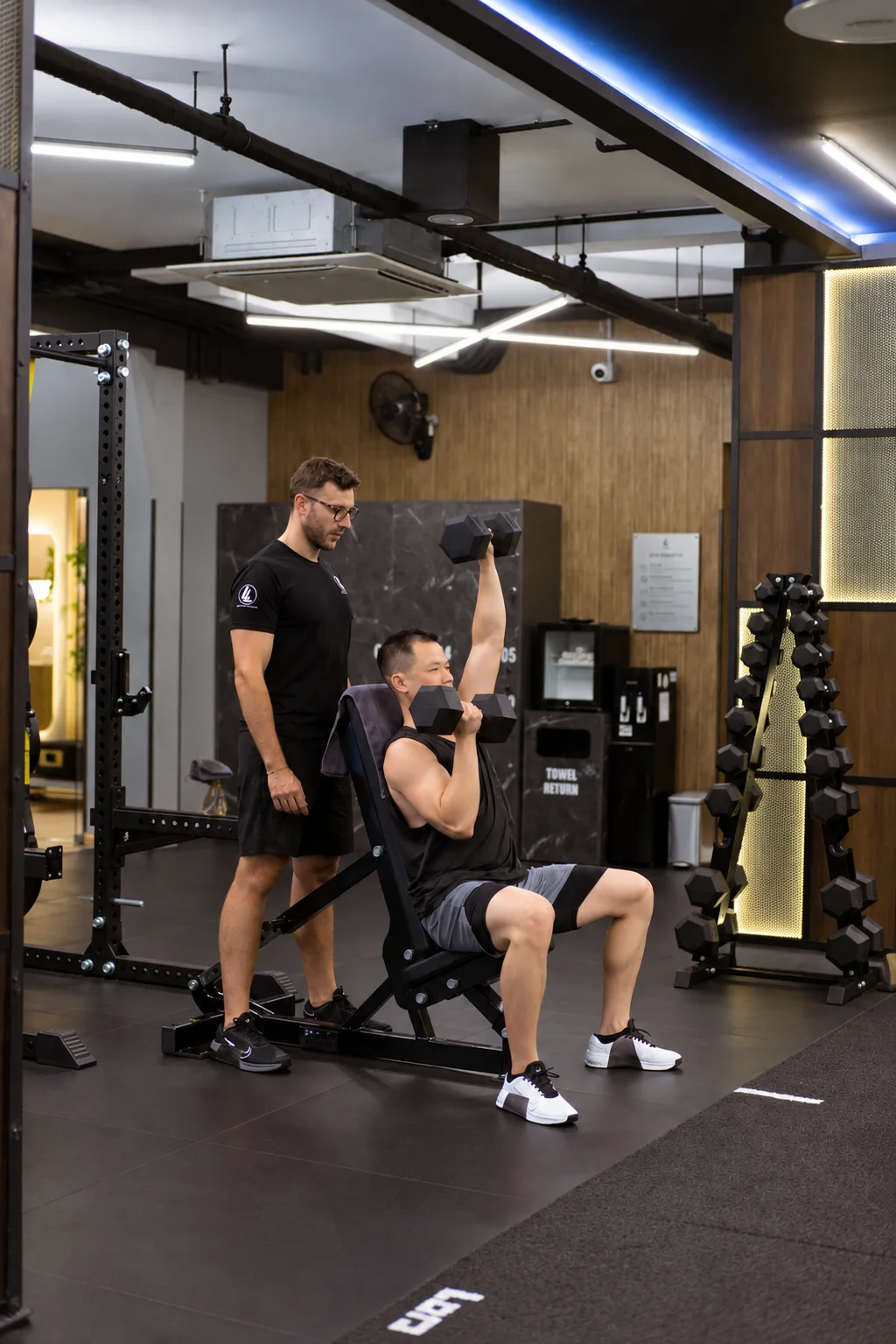 LLFitness personal trainer coaching a client during a workout